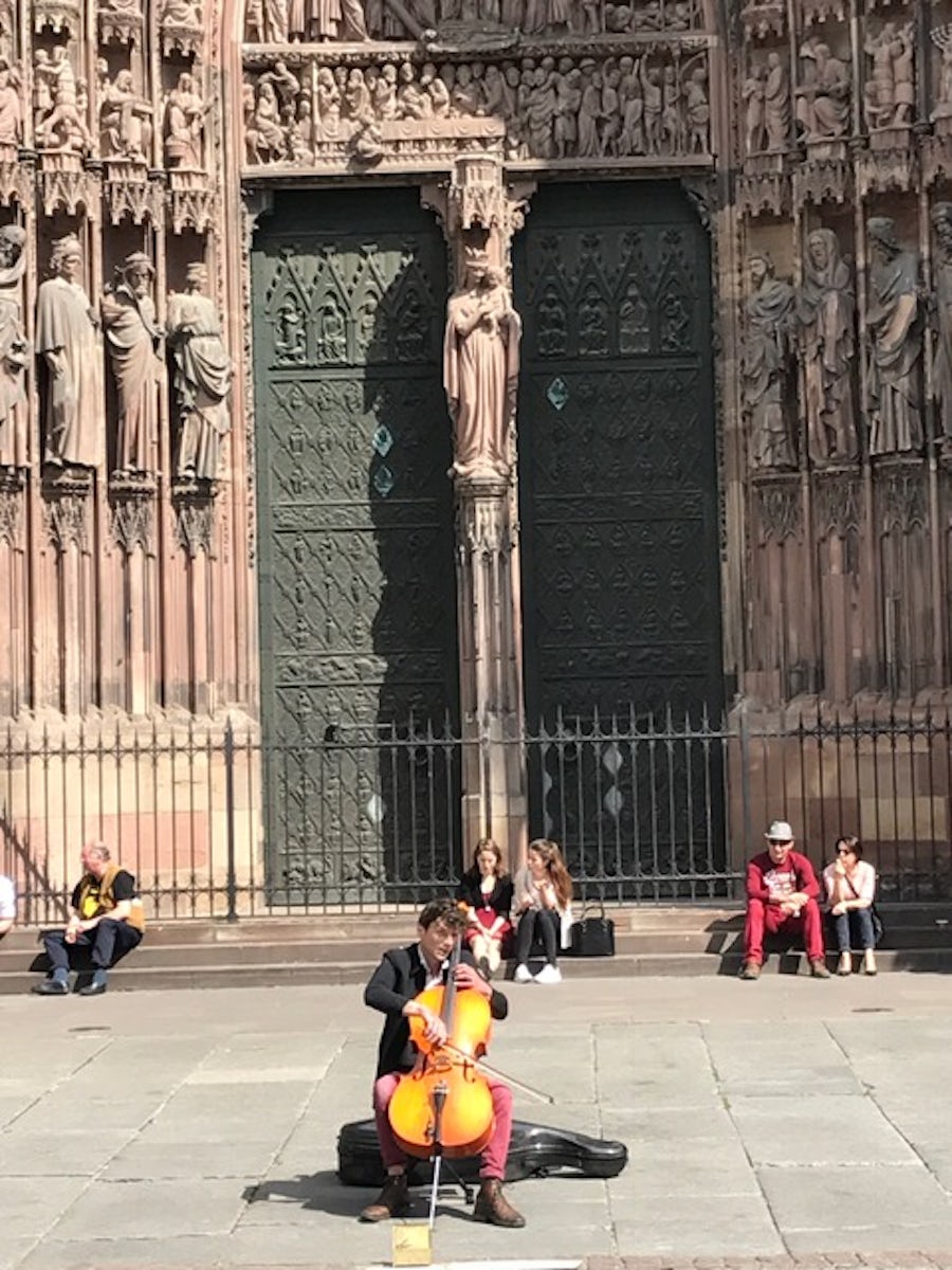 Cellist plays in front of Strasbourg Cathedral