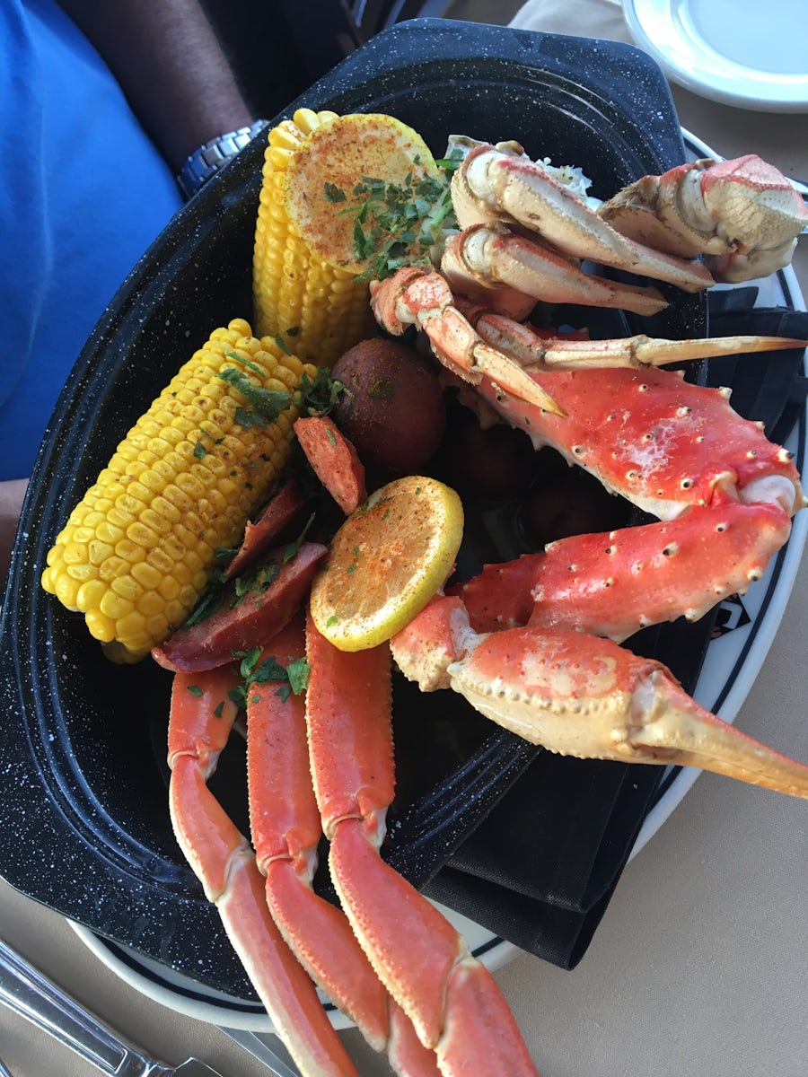 A variety of crab legs, corn on the cob, sausage, and red potatoes dinner a
