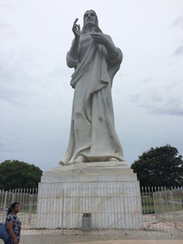 Christ's statue on a hill next to the water.