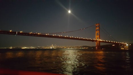 Golden Gate Bridge and San Francisco under the moon during a sunset harbor