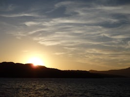 View from ship of sunset behind Nea Kameni, while in the caldera at Santori