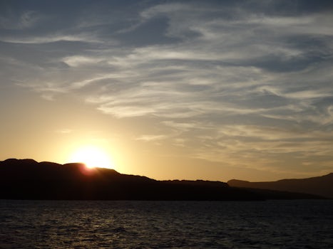 View from ship of sunset behind Nea Kameni, while in the caldera at Santori