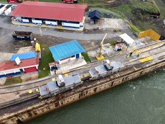 Transit of Panama Canal.   These trains are called mules and help keep ship