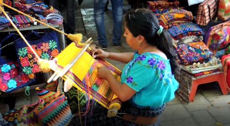 A young lady, near our boat, demonstrating hand-made weaving.