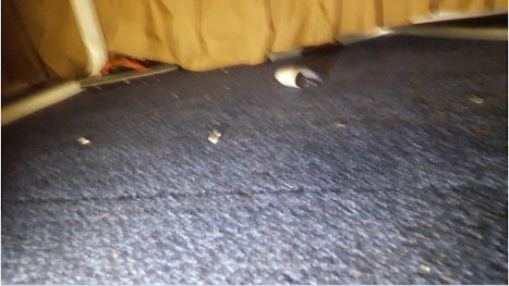 Photo of floor under the bed.  The carpet was dirty, not vacuumed, somebody