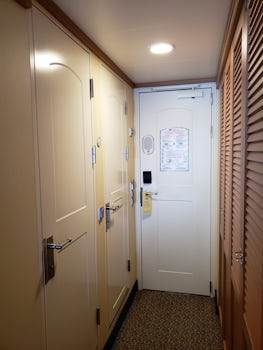 Room hallway 2 bathroom doors on left. Closets on right.