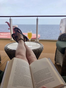 Enjoying a book and mimosa on Deck 8 Waterfront on the last sea day