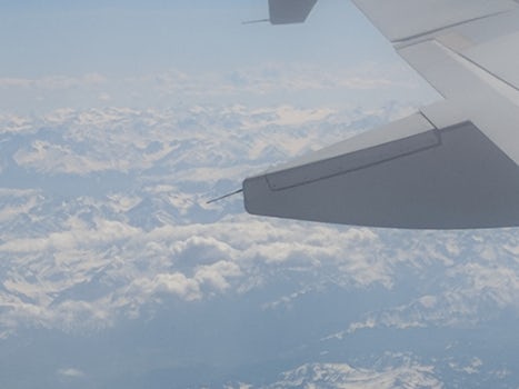 Homeward bound over Europe.  Clouds and mountains below.