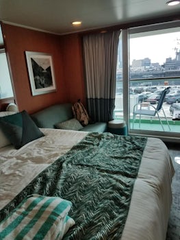 Photo of the stateroom and bed with the balcony curtains open!