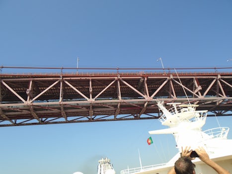 ship going under bridge in lisbon