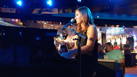 Megan singing at the piano in the Billboard Onboard Bar.