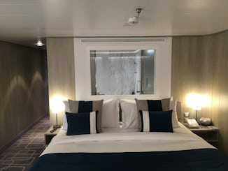 Bed, other side of the glass is bathroom mirror which can be opened