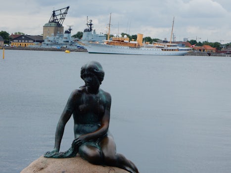 Copenhagen's Little Mermaid with Her Royal Yacht in the background.