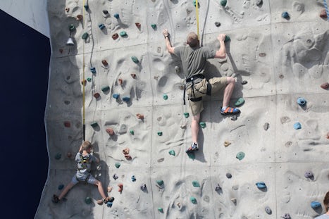 Dad and son climbing the rock wall. 