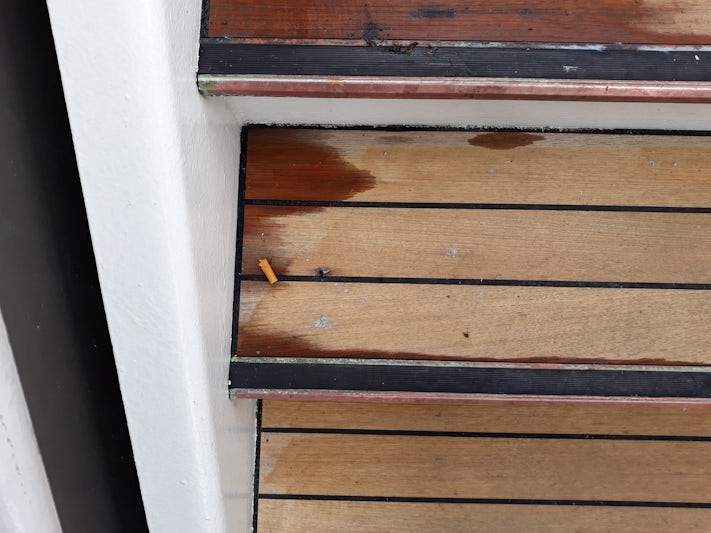 A crews one of many cigarette butt on the deck.