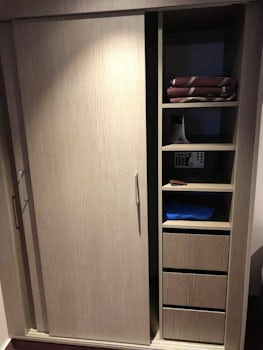 One side of closet with drawers, shelves and safe 