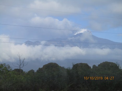 A rare view of white peaked Mount Etna peaking thru the clouds