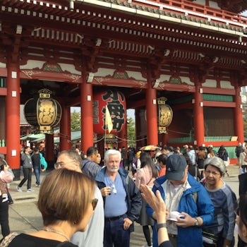 Tour participants at a busy shrine listening intently to the tour guide.