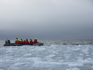 Small boat cruising on the ice field 