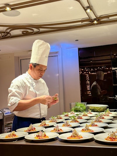 One of the chefs plating our salads for our dinner at Chef's Table specialty restaurant. 