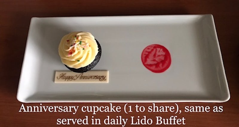 1 [one] cup cake to with us Happy Anniversary [to share?] and a smudge of red dot as if someone had eaten the other cup cake.  Same cup cake served at Lido Buffet daily.