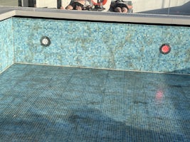 Pool drained with missing mosaics, rust and left light not working.