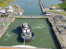 Panama Canal transit.  New canal uses tugs vs tracked mules to keep vessels centered in the lock.
