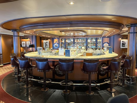 The is the bar of the Commodore Club on Deck 10. Looking the opposite direction is an expanse of windows looking over the bow. 