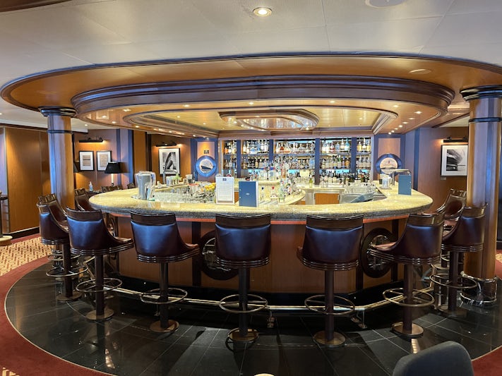 The is the bar of the Commodore Club on Deck 10. Looking the opposite direction is an expanse of windows looking over the bow. 